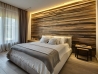 23 a weathered wood clad statement wall with strip lighting on the top gives you light for reading and accents the bed